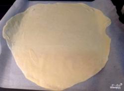 Рецепт - Армянский торт Микадо - Шаг 8 -  Присыпаем стол мукой, берем скалку, раскатываем каждый шарик теста до тончайшего состояния. Только смотрите, чтобы тесто не расползалось. Застилаем противень пергаментной бумагой, выкладываем туда тесто. Выпекаем в духовке при 180 градусах около 7-10 минут, до золотистого цвета.