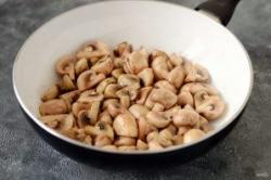 Рецепт - Чашушули с грибами - Шаг 3 -  Разогрейте сковороду с маслом. Начните обжаривать шампиньоны на среднем огне, периодически помешивайте. Когда шампиньоны начнут выделять жидкость, прибавьте температуру и выпаривайте ее.