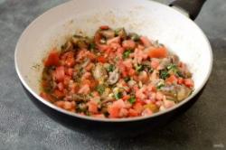 Рецепт - Чашушули с грибами - Шаг 7 -  Добавьте мелко порубленный помидор, соль, черный перец и хмели-сунели. Влейте немного воды, потушите все вместе 5-7 минут.