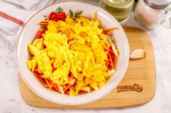 Рецепт - Салат Быстрее некуда - Шаг 7 -  Скрутите яичные блинчики рулетиками и нарежьте их лентами. Добавьте к остальным ингредиентам.