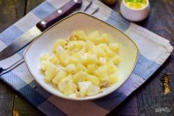 Рецепт - Салат Царский с ананасами - Шаг 6 -  Кольца ананасов нарежьте небольшими кубиками, выложите поверх курицы. Это будет второй слой.