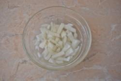 Рецепт - Салат с копчёной курицей и кукурузой - Шаг 2 -  Первым делом займитесь маринованием лука. Его необходимо очистить от шелухи и ополоснуть в холодной воде. Затем очищенный лук мелко нарежьте и залейте уксусом. Оставьте постоять минут на 7-10. Затем уксус слейте, а сам лук промойте в холодной воде. Этот процесс уберет резкий аромат самого лука и его горечь, но придаст ему маринованный вкус.