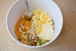 Рецепт - Салат с копчёной курицей и кукурузой - Шаг 6 -  Остывшие куриные яйца очистите от скорлупы и нарежьте. Нарезать яйца удобно и быстро с помощью яйцерезки. Добавьте в салат нарезанные яйца и маринованный лук. Заправьте салат небольшим количеством майонеза и все хорошо перемешайте.