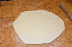 Рецепт - ХАЧАПУРИ ПО-МЕГРЕЛЬСКИ - Шаг 10 -  Аккуратно переверните заготовку швом вниз. Раскатайте ее скалкой или расплющите руками в круг диаметром примерено 20-22 см и толщиной около 8-10 мм.