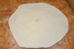 Рецепт - ХАЧАПУРИ ПО-МЕГРЕЛЬСКИ - Шаг 11 -  По центру сделайте отверстие пальцем руки или 2-3 небольших надреза кончиком ножа (или проколите заготовку по периметру зубочисткой). Это нужно для того, чтобы во время выпекания образующийся пар имел выход и хачапури не раздулся.