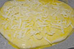 Рецепт - ХАЧАПУРИ ПО-МЕГРЕЛЬСКИ - Шаг 13 -  Сверху посыпьте изделие оставшимся тертым сыром. Отправьте противень с хачапури в разогретую духовку. Выпекайте примерно 20 минут. Помните, что время выпекания в вашей духовке может быть изменено. Как проверить готовность выпечки? Когда увидите, что сверху образовалась румяная корочка, проткните ее деревянной зубочисткой. Если она вышла сухой, значит готово.