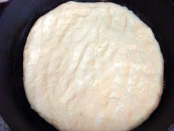 Рецепт - ХАЧАПУРИ ИМЕРЕТИНСКИЕ - Шаг 8 -  Кладем тесто узлом вниз и прижимаем его, формируя лепешку. Затем тонко ее раскатываем.