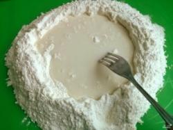 Рецепт - Хинкали - Шаг 2 -  Просейте муку на рабочую поверхность, сделайте в центре углубление, добавьте воду и соль. Постепенно смешивайте муку с водой.