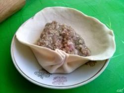 Рецепт - Хинкали - Шаг 9 -  Для удобства формовки хинкали поместите лепешку на блюдце. В центр лепешки положите 1-1,5 ст. л. фарша, соберите тесто складками по кругу. По традиции в хинкали должно быть не менее 19 складок.