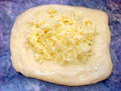 Рецепт - ХАЧАПУРИ С СЫРОМ В ДУХОВКЕ ОСОБЕННЫЙ - Шаг 9 -  На один смазанный маслом пласт теста положить второй, посыпать начинкой и защипать края хачапури так, чтобы сыр оказался внутри.