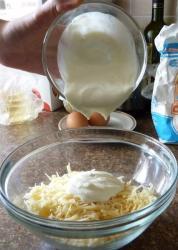 Рецепт - ХАЧАПУРИ ЛЕНИВЫЕ С СЫРОМ И ЗЕЛЕНЬЮ - Шаг 2 -  риговорённый к казни сыр натираем на крупной тёрке, кладём его в глубокую миску, выливаем в миску кефир или сметану.