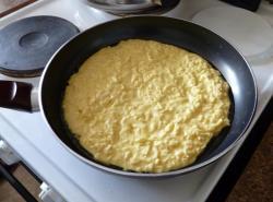 Рецепт - ХАЧАПУРИ ЛЕНИВЫЕ С СЫРОМ И ЗЕЛЕНЬЮ - Шаг 6 -  Быстро выкладываем наше сырное тесто на разогретую сковороду, распределяя его ложкой по всей поверхности, словно толстый большой блин. Если вы использовали для теста пресный сыр, хачапури нужно слегка присолить. Затем мы щедро посыпаем тесто зеленью, накрываем крышкой и ждём несколько минут, пока не появится дразнящий аромат. 